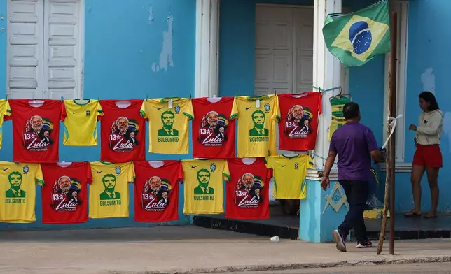Red T-shirts depicting Brazilian President Luiz Inacio Lula da Silva, who is running for reelection, and yellow T-shirts depicting opposition presidential candidate Sen. Flavio Bolsonaro hang for sale outside a building ahead of Brazil's presidential runoff election in Autazes, Amazonas state, Brazil, Saturday, Oct. 24, 2026. (AP Photo/Edmar Barros)
