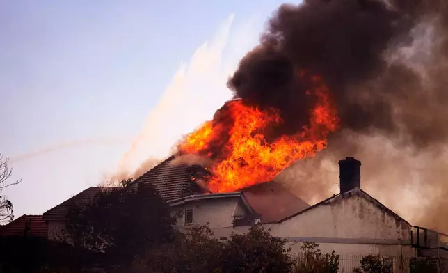 A roof engulfed in flames is seen during the Norte Fire on Friday, Oct. 16, 2026, in San Juan Capistrano, Calif. (AP Photo/Jae C. Hong)
