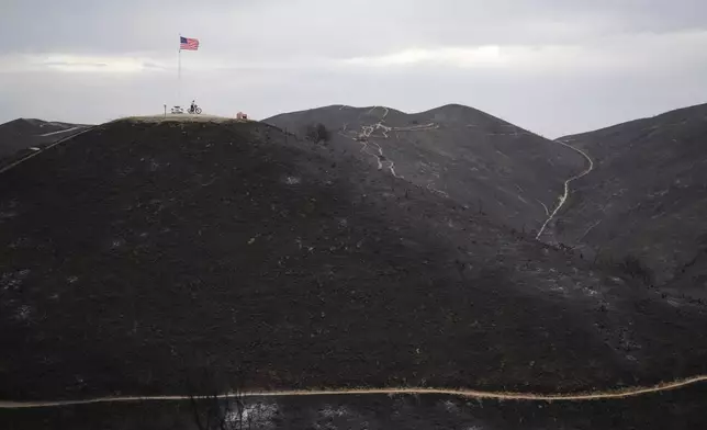 A biker looks over a hillside burned by the Norte Fire from Patriot Hill Saturday, Oct. 17, 2026, in San Juan Capistrano, Calif. (AP Photo/Gregory Bull)