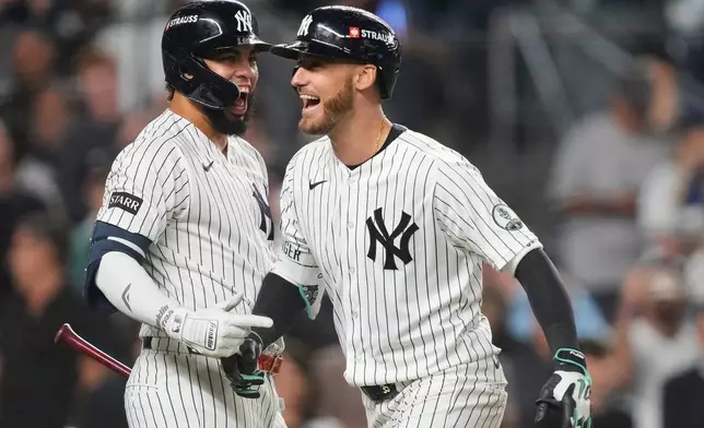 New York Yankees' Cody Bellinger, right, celebrates with teammate Luis García Jr., left, after hitting a three-run home run against the Boston Red Sox during the sixth inning in Game 2 of baseball's American League Wild Card Series, Wednesday, Sept. 30, 2026, in New York. (AP Photo/Yuki Iwamura)