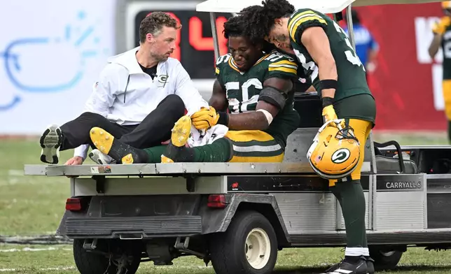 Green Bay Packers safety Evan Williams (33) consoles his teammate linebacker Edgerrin Cooper (56) after he was injured during the second half of an NFL football game against the Tampa Bay Buccaneers in Tampa, Fla., Sunday, Oct. 4, 2026. (AP Photo/Jason Behnken)