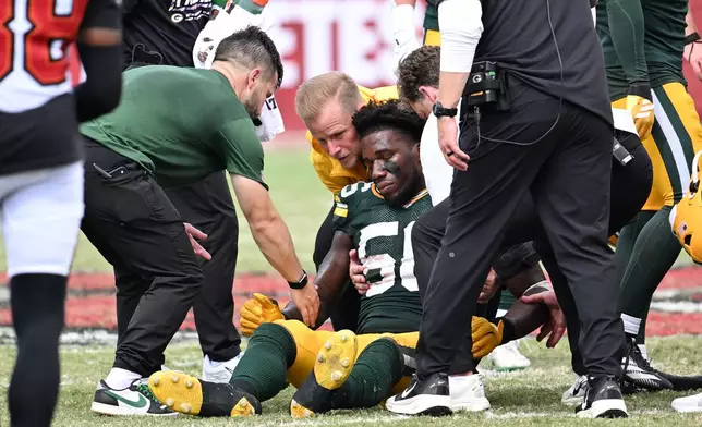 Green Bay Packers linebacker Edgerrin Cooper (56) is assisted off the field during the second half of an NFL football game against the Tampa Bay Buccaneers in Tampa, Fla., Sunday, Oct. 4, 2026. (AP Photo/Jason Behnken)