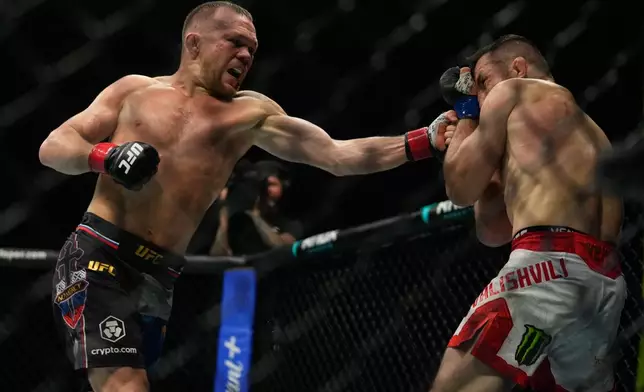 Russia's Petr Yan, left, punches Merab Dvalishvili of Georgia during the Bantamweight title bout at the mixed martial arts UFC Fight Night on Saturday, Oct. 24, 2026. (AP Photo/Altaf Qadri)