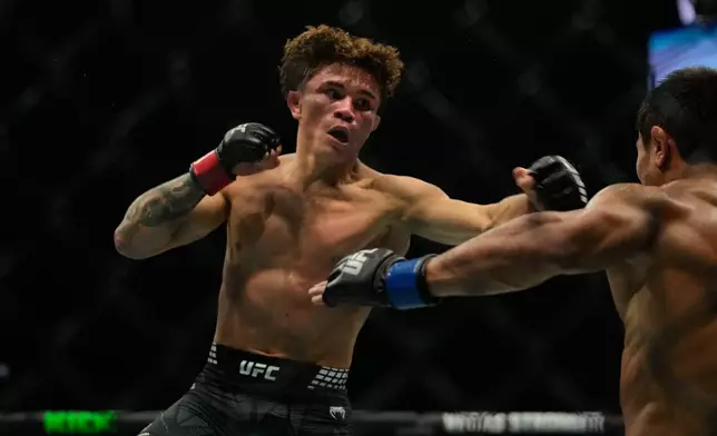 Lone'er Kavanagh of Britain, left, punches Uzbekistan's Ramazan Temirov, during flyweight bout at the mixed martial arts UFC Fight Night on Saturday, Oct. 24, 2026. (AP Photo/Altaf Qadri)
