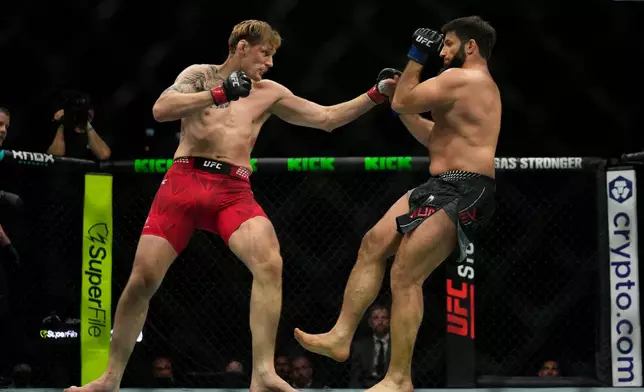 Russia's Alexander Volkov, left, punches Rizvan Kuniev during a heavyweight bout at the mixed martial arts UFC Fight Night on Saturday, Oct. 24, 2026. (AP Photo/Altaf Qadri)
