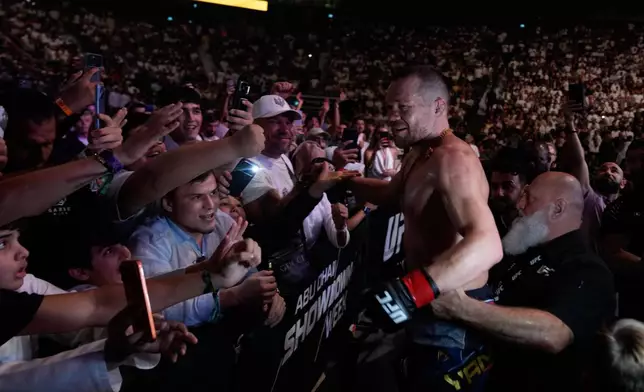 Russia's Petr Yan, right, celebrates with his fans after beating Merab Dvalishvili of Georgia to win the Bantamweight title bout at the mixed martial arts UFC Fight Night on Saturday, Oct. 24, 2026. (AP Photo/Altaf Qadri)