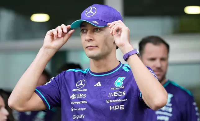 Mercedes driver George Russell of Britain adjust his cap at the paddock ahead of the Singapore Formula One Grand Prix weekend at the Marina Bay Street Circuit in Singapore, Thursday, Oct. 8, 2026. (AP Photo/Vincent Thian)