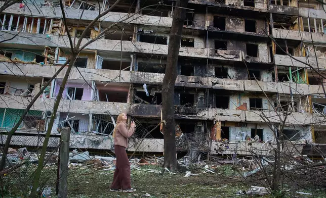 A young woman reacts as she looks at her damaged home after Russia's night missile attack in Kyiv, Ukraine, Wednesday, Oct. 14, 2026. (AP Photo/Efrem Lukatsky)