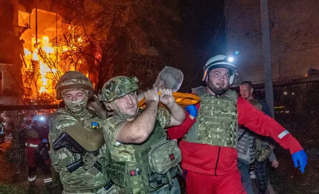 Rescuers evacuate an injured civilian after a residential building was hit following a Russian air attack in Kharkiv, Ukraine, Tuesday, Oct. 13, 2026. (AP Photo/Andrii Marienko)