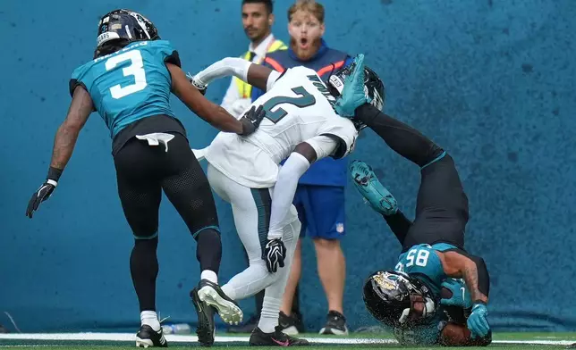 Jacksonville Jaguars tight end Brenton Strange (85) is flipped through the air as he is held just short of the end zone during an NFL football game against Philadelphia Eagles in London, Sunday, Oct. 11, 2026. (AP Photo/Alastair Grant)