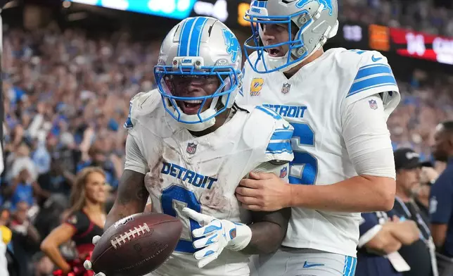 Detroit Lions running back Jahmyr Gibbs (0) celebrates his touchdown run with quarterback Jared Goff (16) against the Arizona Cardinals during the second half of an NFL football game in Glendale, Ariz., Sunday, Oct. 11, 2026. (AP Photo/Rick Scuteri)