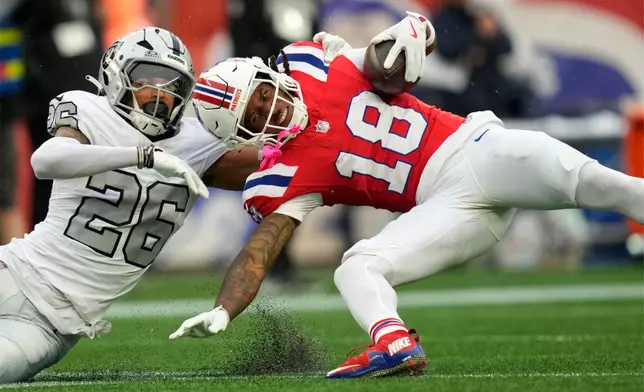 New England Patriots wide receiver Kyle Williams (18) is dragged down by Las Vegas Raiders cornerback Darien Porter (26) after catching a long pass during an NFL football game in Foxborough, Mass., Sunday, Oct. 11, 2026. (AP Photo/Charles Krupa)