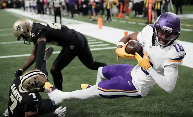 Minnesota Vikings wide receiver Justin Jefferson (18) catches a touchdown pass against New Orleans Saints safety Jonas Sanker (7) and cornerback Quincy Riley during the second half of an NFL football game in New Orleans, Sunday, Oct. 11, 2026. (AP Photo/Matthew Hinton)