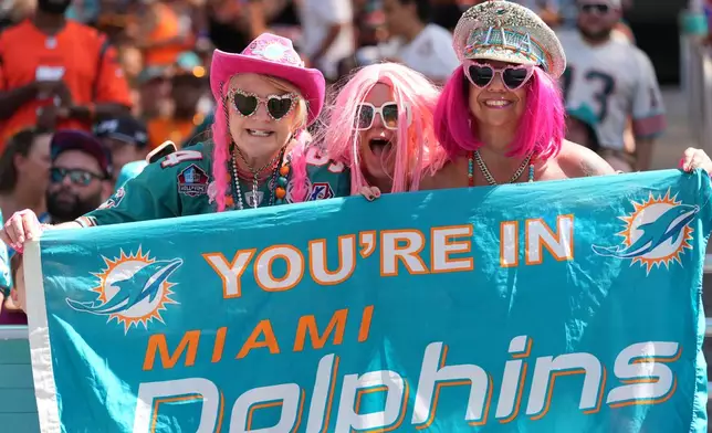 Miami Dolphins fans cheer the team during the first half of an NFL football game against the Cincinnati Bengals in Miami Gardens, Fla., Sunday, Oct. 11, 2026. (AP Photo/Rebecca Blackwell)