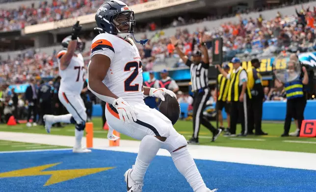 Denver Broncos running back J.K. Dobbins, right, runs in for a touchdown during the first half of an NFL football game against the Los Angeles Chargers, Sunday, Oct. 11, 2026, in Inglewood, Calif. (AP Photo/Scott Strazzante) Correction corrects month to Oct.
