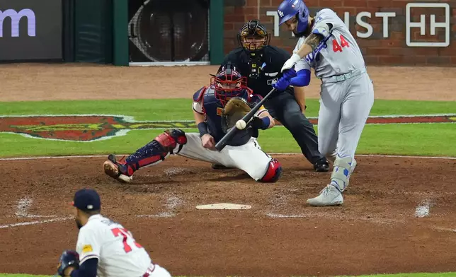 Los Angeles Dodgers center fielder Andy Pages (44) hits a two run RBI-single off a pitch by Atlanta Braves pitcher Didier Fuentes, bottom left, during the seventh inning in Game 4 of baseball's National League Division Series, Wednesday, Oct. 7, 2026, in Atlanta. (AP Photo/Colin Hubbard)