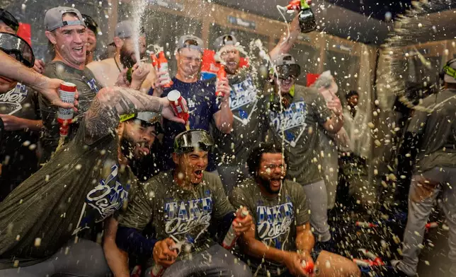 Los Angeles Dodgers players celebrate winning Game 4 of baseball's National League Division Series against the Atlanta Braves, Wednesday, Oct. 7, 2026, in Atlanta. (AP Photo/Mike Stewart)
