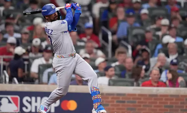 Los Angeles Dodgers left fielder Teoscar Hernández hits a single during the seventh inning in Game 4 of baseball's National League Division Series against the Atlanta Braves, Wednesday, Oct. 7, 2026, in Atlanta. (AP Photo/Mike Stewart)
