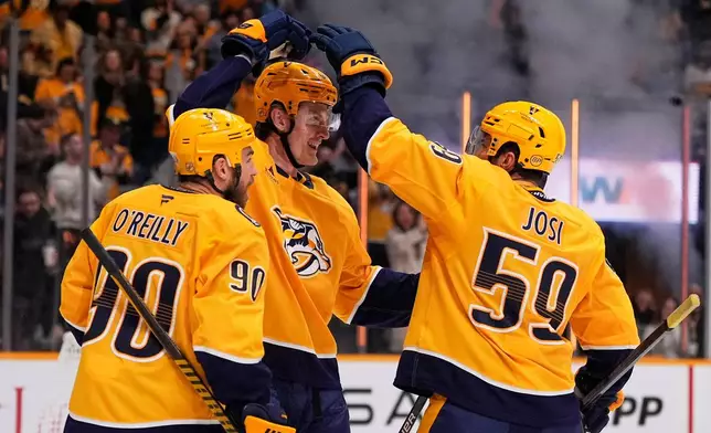 Nashville Predators center Adam Edstrom, middle, celebrates his goal with Ryan O'Reilly (90) and Roman Josi (59) during the second period of an NHL hockey game against the St. Louis Blues, Saturday, Oct. 17, 2026, in Nashville, Tenn. (AP Photo/George Walker IV)