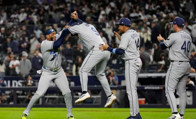 Tampa Bay Rays' Yandy Díaz, left, Jorge Mateo (9), Chandler Simpson (14) and Nick Fortes (40) celebrate the team's win in Game 3 of baseball's American League Division Series against the New York Yankees, Wednesday, Oct. 7, 2026, in New York. (AP Photo/Seth Wenig)
