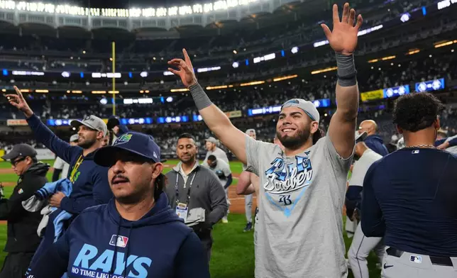 Tampa Bay Rays' Jonathan Aranda, center right, and the rest of the team celebrate their win in Game 3 of baseball's American League Division Series against the New York Yankees Wednesday, Oct. 7, 2026, in New York. (AP Photo/Seth Wenig)