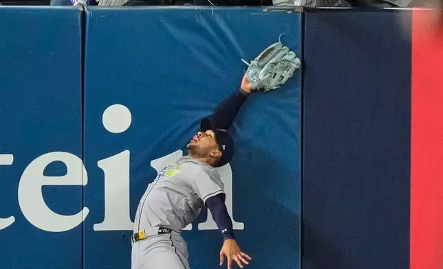 Tampa Bay Rays left fielder Victor Mesa Jr. makes an attempt on a ball interfered with by fans that umpires reviewed and ruled a run-scoring double by New York Yankees' Anthony Volpe during the sixth inning in Game 3 of baseball's American League Division Series, Wednesday, Oct. 7, 2026, in New York. (AP Photo/Yuki Iwamura)