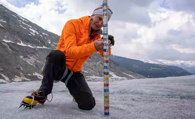 FILE - ETH (Swiss Federal Institute of Technology) glaciologist and head of the Swiss measurement network Glamos, Matthias Huss, checks the thickness of the Rhone Glacier near Goms, Switzerland, June 16, 2023. (AP Photo/Matthias Schrader, File)