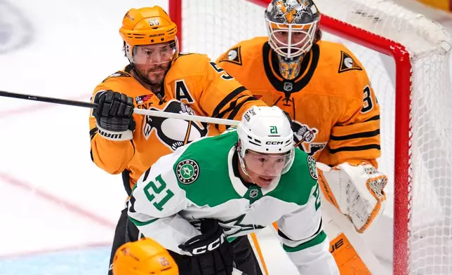 Pittsburgh Penguins' Kris Letang (58) defends against Dallas Stars' Jason Robertson (21) in front of Penguins goalie Arturs Silovs, top right, during the first period of an NHL hockey game in Pittsburgh, Saturday, Oct. 10, 2026. (AP Photo/Gene J. Puskar)