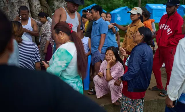 Survivors of the flash floods in Nepal in August this year wait to receive clothing for their children at a temporary holding center in Nepal's Nuwakot district, Sept. 23, 2026. (AP Photo/Niranjan Shrestha)