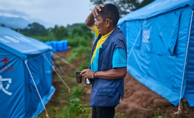 Mangale Tamang, who survived the Nepal's 2015 earthquake and the flash floods in August this year, stands at a temporary holding center in Nepal's Nuwakot district, Sept. 23, 2026. (AP Photo/Niranjan Shrestha)