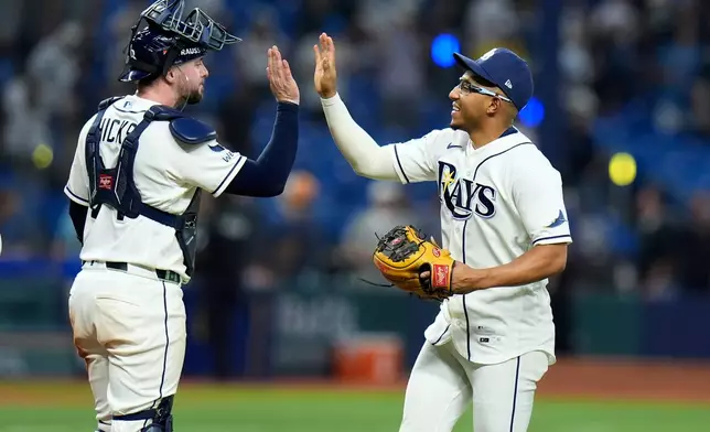 Tampa Bay Rays' Richie Palacios, right, and Liam Hicks celebrate a victory over the New York Yankees in Game 2 of an American League Division Series baseball game Monday, Oct. 5, 2026, in St. Petersburg, Fla. (AP Photo/Chris O'Meara)