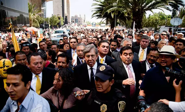 FILE - Cuauhtemoc Cardenas, center, a founder of the Party of the Democratic Revolution, PRD, leaves the Monument of the Revolution where he presented his party's energy reform proposal in Mexico City, Aug. 19, 2013. (AP Photo/Eduardo Verdugo, File)