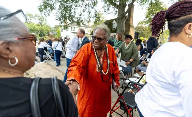 Cherisse Gardener, a member of a family descended from the church’s early congregation, greets attendees during the rededication ceremony of the African Baptist Meeting House, now known as the First Baptist Church of Williamsburg, in Williamsburg, Va., Friday, Oct. 9, 2026. (AP Photo/Mike Kropf)