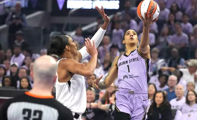 Golden State Valkyries forward Gabby Williams (1) drives to the basket against Las Vegas Aces center A'ja Wilson, second from right, during the first half of Game 1 of the WNBA basketball semifinals in San Francisco, Sunday, Oct. 4, 2026. (AP Photo/Tony Avelar)