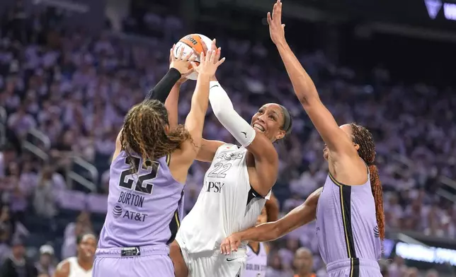 Las Vegas Aces center A'ja Wilson (22) drives to the basket against Golden State Valkyries' Kiah Stokes, right, and Veronica Burton (22) during the first half of Game 1 of the WNBA basketball semifinals in San Francisco, Sunday, Oct. 4, 2026. (AP Photo/Tony Avelar)