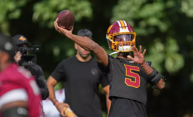 Washington Commanders' quarterback Jayden Daniels throws the ball during an NFL football practice in Hertfordshire, England, Friday, Oct. 2, 2026. (AP Photo/Alastair Grant)