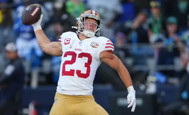 San Francisco 49ers running back Christian McCaffrey (23) spikes the ball after scoring on a touchdown run against the Seattle Seahawks during the first half of an NFL football game Sunday, Oct. 11, 2026, in Seattle. (AP Photo/Lindsey Wasson)