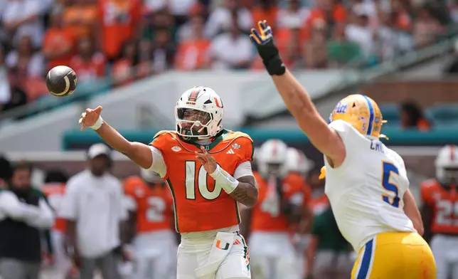 Miami quarterback Darian Mensah (10) throws a pass as Pittsburgh defensive lineman Zach Crothers (5) defends during the first half of an NCAA college football game, Saturday, Oct. 24, 2026, in Miami Gardens, Fla. (AP Photo/Rebecca Blackwell)
