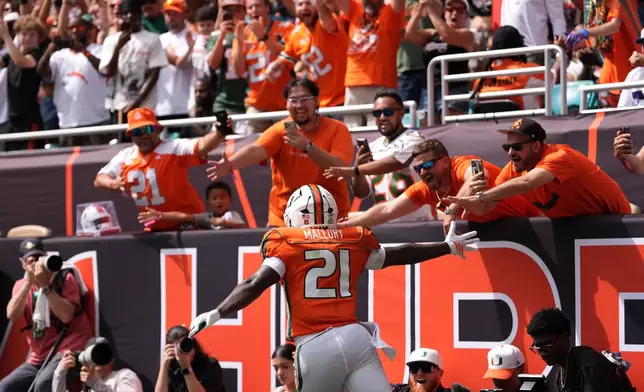 Miami running back Javian Mallory (21) celebrates with fans after scoring a touchdown during the first half of an NCAA college football game against Pittsburgh, Saturday, Oct. 24, 2026, in Miami Gardens, Fla. (AP Photo/Rebecca Blackwell)
