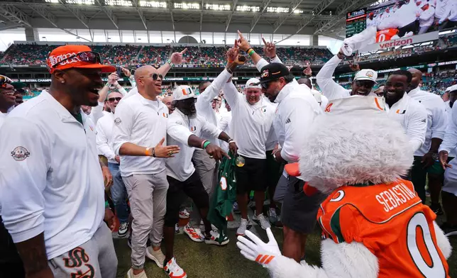 Members of Miami's 2001 National Championship football team celebrate with Miami mascot Sebastian the Ibis as they are honored at halftime of an NCAA college football game between Miami and Pittsburgh, Saturday, Oct. 24, 2026, in Miami Gardens, Fla. (AP Photo/Rebecca Blackwell)
