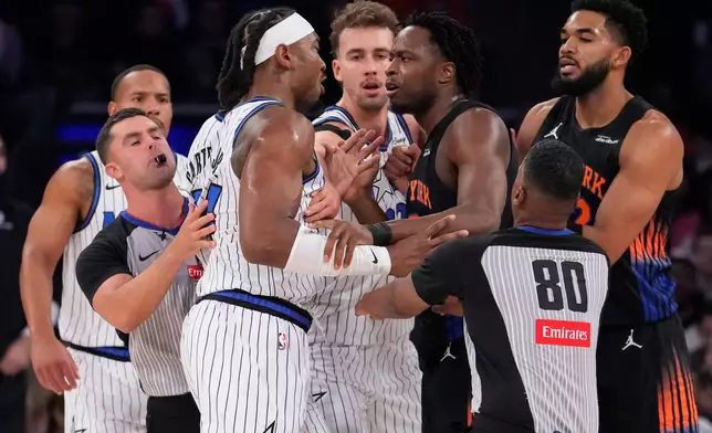 New York Knicks forward Og Anunoby (8), third from right, argues with Orlando Magic center Wendell Carter Jr. (34), third from left, during the first half of an NBA basketball game, Sunday, Oct. 25, 2026, in New York. (AP Photo/Yuki Iwamura)