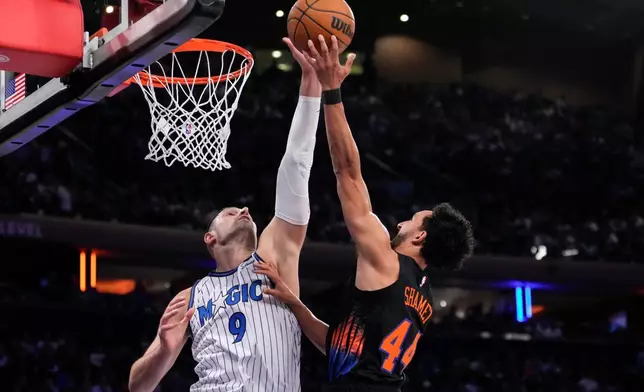 Orlando Magic center Nikola Vucevic (9) blocks New York Knicks guard Landry Shamet (44) during the first half of an NBA basketball game, Sunday, Oct. 25, 2026, in New York. (AP Photo/Yuki Iwamura)