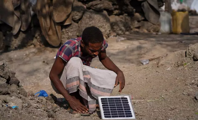 FILE - A displaced man inspects a small solar panel at a makeshift camp in Taiz, Yemen, March 13, 2026. (AP Photo/Abdulnasser Alseddik, File)