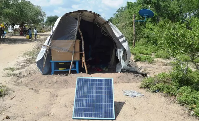 FILE - A family displaced by flooding has a solar panel set up outside their tent in Garsen town within Tana River County, Kenya, Dec. 3, 2023. (AP Photo/Gideon Maundu, File)