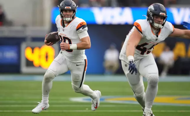 Denver Broncos quarterback Bo Nix, left, runs the ball as tight end Nate Adkins blocks during the second half of an NFL football game against the Los Angeles Chargers, Sunday, Oct. 11, 2026, in Inglewood, Calif. (AP Photo/Gregory Bull)