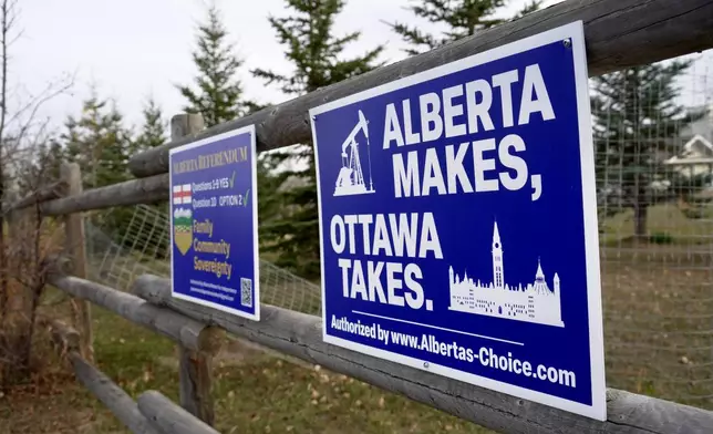 Political signs are posted on a property's fence in Wainwright, Alberta, Canada, Monday, Oct. 19, 2026. (AP Photo/Ty O'Neil)