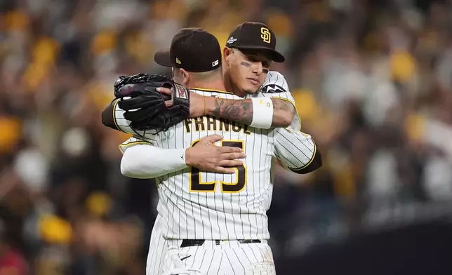 San Diego Padres third baseman Manny Machado celebrates with first baseman Ty France (25) after defeating the Chicago Cubs in Game 2 of the National League Wild Card baseball playoff series Wednesday, Sept. 30, 2026, in San Diego. (AP Photo/Gregory Bull)