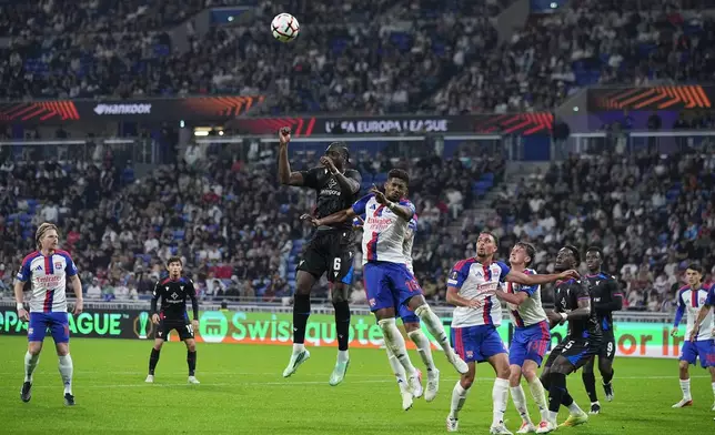 Crystal Palace's Jaydee Canvot, left, and Lyon's Tanner Tessmann battle for a header during the Europa League opening phase soccer match between Lyon and Crystal Palace in Lyon, France, Thursday, Oct. 15, 2026. (AP Photo/Laurent Cipriani)