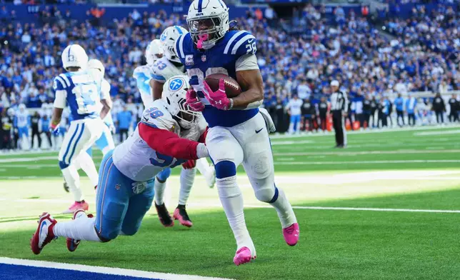 Indianapolis Colts running back Jonathan Taylor (28) runs for a touchdown past Tennessee Titans defensive tackle Jeffery Simmons (98) during the second half of an NFL football game Sunday, Oct. 18, 2026, in Indianapolis. (AP Photo/AJ Mast)