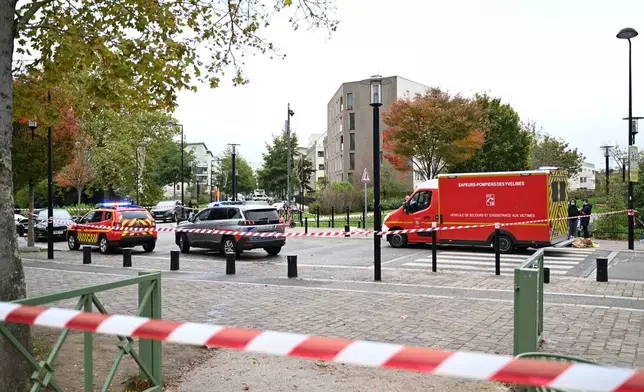 Emergency vehicles sit near a park after a shooting in Trappes, outside Paris, Friday, Oct. 23, 2026. (AP Photo/Emma Da Silva)